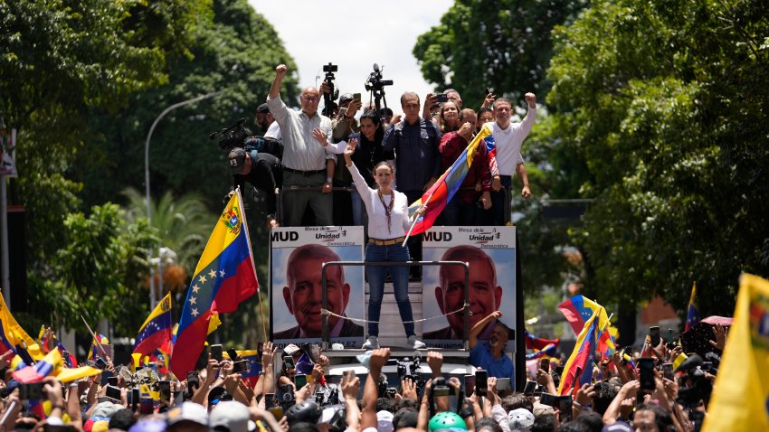 Opposition leader Maria Corina Machado holds a national flag while waving to supporters as she arrives for a rally in Caracas, Venezuela, Saturday, Aug. 3, 2024.