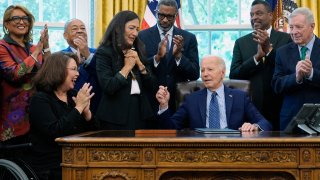 President Joe Biden, who is joined by civil rights leaders, community members, and elected officials, talks after handing Interior Secretary Deb Haaland, fourth from left, the pen he used to sign a proclamation in the Oval Office of the White House in Washington, Friday, Aug. 16, to designate the Springfield 1908 Race Riot National Monument.