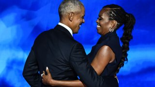 Former President Barack Obama hugs his wife and former First Lady Michelle Obama