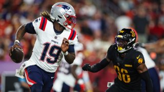 Joe Milton III #19 of the New England Patriots scrambles from the pressure of Kyu Blu Kelly #36 of the Washington Commanders during the third quarter of a preseason game at Commanders Field on August 25, 2024 in Landover, Maryland.