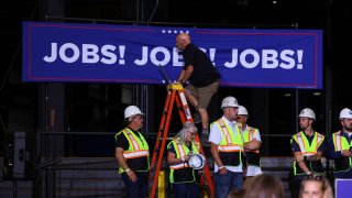 A staff member stands on a ladder on the day of Republican presidential nominee and former U.S. President Donald Trump’s visit in Potterville, Michigan, U.S., August 29, 2024. 