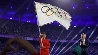 Karen Bass, Mayor of Los Angeles, waves the Olympic flag as Thomas Bach, President of International Olympic Committee, applauds during the Closing Ceremony of the Olympic Games Paris 2024 at Stade de France on August 11, 2024 in Paris, France.