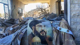 A portrait of Hezbollah chief Hassan Nasrallah sits amid destruction in a area targeted overnight by Israeli airstrikes in Saksakiyeh on September 26, 2024.