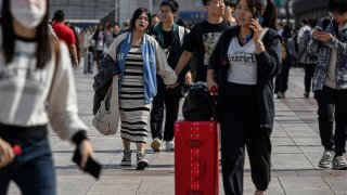 Passengers arrive at the Beijing railway station on the first day of peak travel ahead of the National Day holidays in China’s capital city on Sept. 29, 2023.