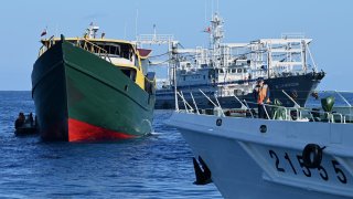 A vessel identified by the Philippine Coast Guard as “Chinese maritime militia” (back R) and a China Coast Guard vessel (front R) sailing near the Philippine military chartered Unaizah May 4 (L) during its supply mission to Second Thomas Shoal in the disputed South China Sea on March 5, 2024. 