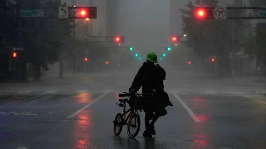 Ron Rook, who said he was looking for people in need of help or debris to clear, walks through windy and rainy conditions on a deserted street in downtown Tampa, Fla., during the approach of Hurricane Milton, Wednesday, Oct. 9, 2024.