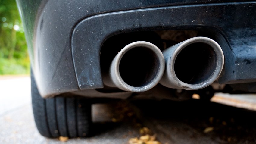 An exhaust pipe hangs from a car.