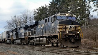 A Norfolk Southern freight train pulled by Locomotive 7565, a GE ES44DC Evolution Series diesel locomotive.