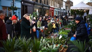 Customers buy flowers on stalls at Columbia Road Flower Market in East London.