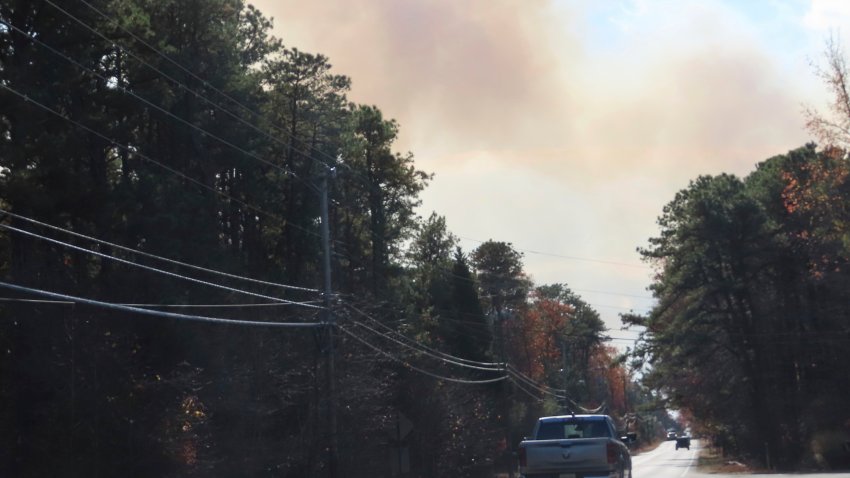 Smoke from a forest fire rises above the trees in Evesham, N.J. on Thursday, Nov. 7, 2024, when firefighters said conditions were the driest in New Jersey in nearly 120 years.