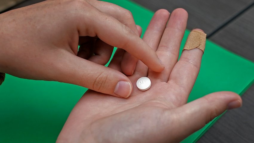 FILE - A patient prepares to take the first of two combination pills,