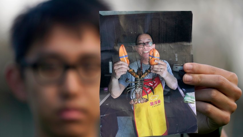 Harrison Li holds a photo of his father, Kai Li, as he poses for a photo