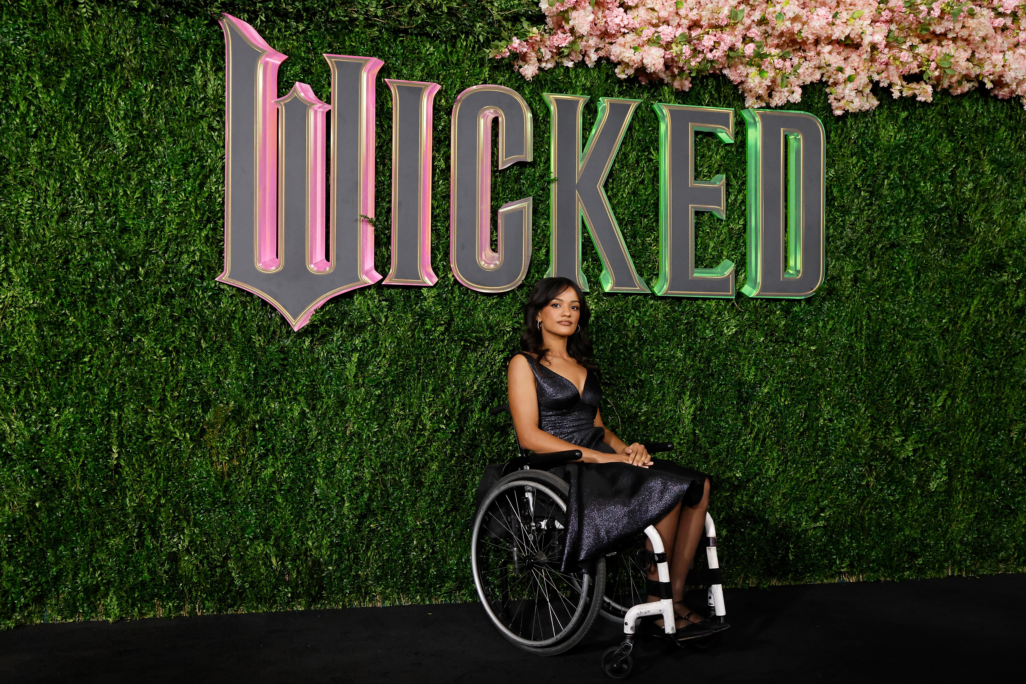 Marissa Bode in front of a sign for "Wicked"