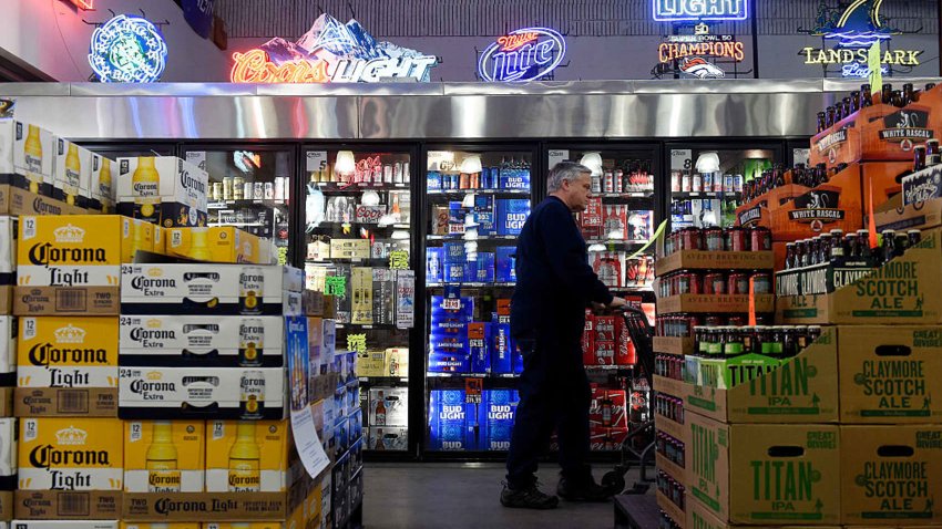 A customer walks past the beer coolers at Chambers Wine and Liquor in Aurora, Colorado.