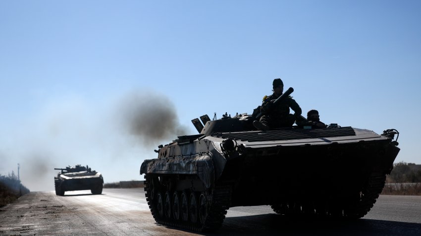 Syrian opposition fighters drive a seized Syrian army armored vehicle.