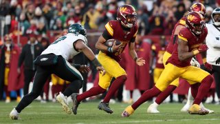 LANDOVER, MARYLAND – DECEMBER 22: Jayden Daniels #5 of the Washington Commanders runs the ball against Nolan Smith Jr. #3 ofthe Philadelphia Eagles during the fourth quarter at Northwest Stadium on December 22, 2024 in Landover, Maryland. (Photo by Scott Taetsch/Getty Images)