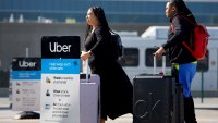 Travelers wait for an Uber ride-share vehicle at Los Angeles International Airport in Los Angeles on Feb. 8, 2023.