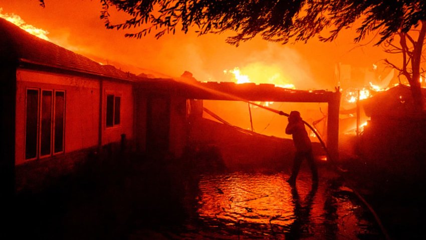 A firefighter douses flames during the Eaton fire in Pasadena, California on January 08, 2025. 