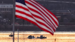Rescuers on boats work as the sun rises at the site of the crash in the Potomac River after a Black Hawk helicopter and an American Eagle flight 5342 approaching Reagan Washington National Airport collided and crashed outside Washington, U.S., January 30, 2025. 