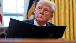 U.S. President Donald Trump signs executive orders in the Oval Office at the White House in Washington, U.S., Jan. 30, 2025.