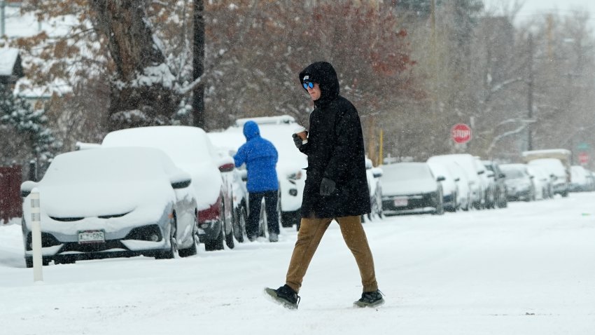 A pedestrian crosses First Avenue as a winter storm sweeps over the intermountain West, plunging temperatures into the single digits and bringing along a light snow in its wake Sat. Jan. 18, 2025, in Denver.