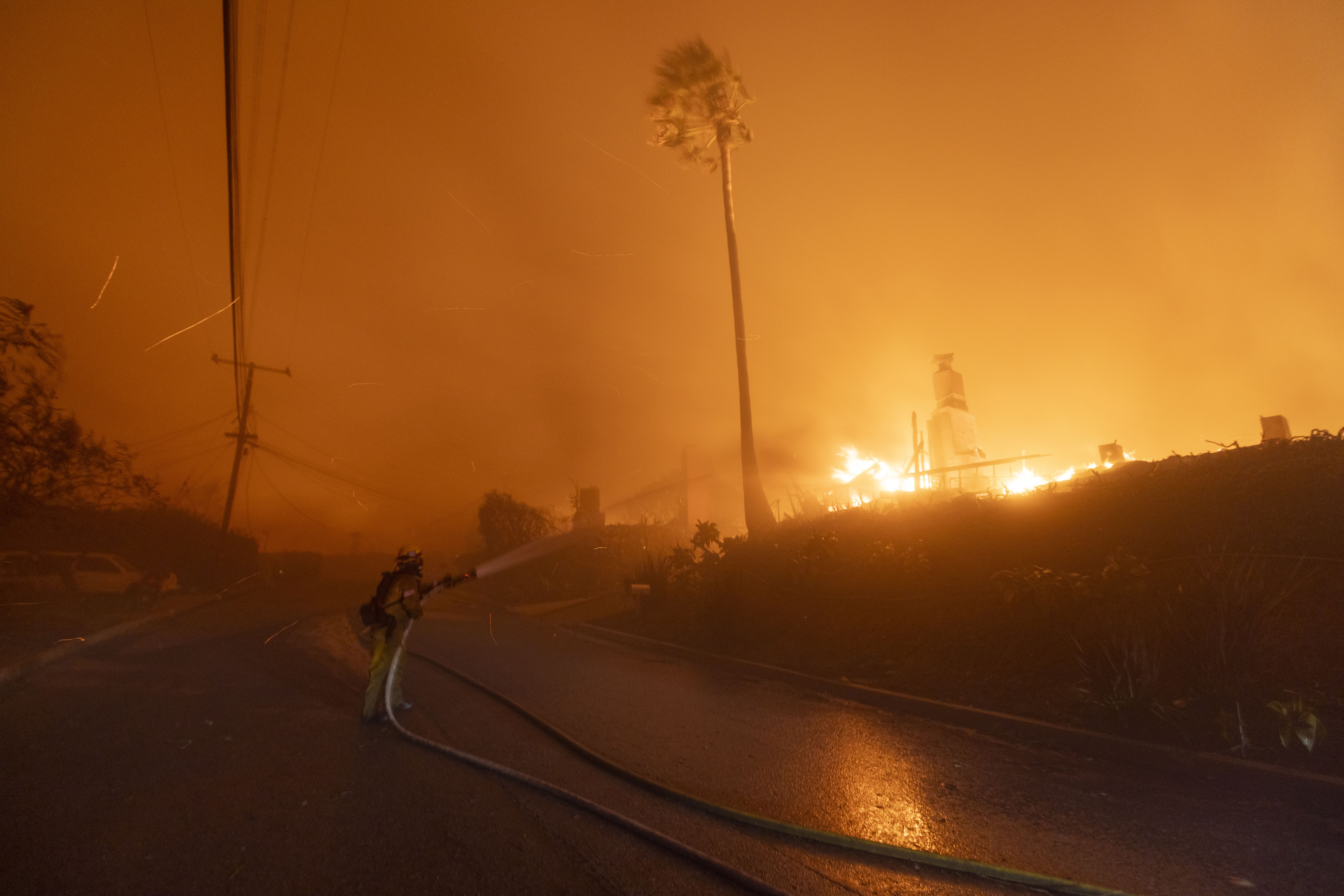 A firefighter battles the blaze on El Medio Avenue during the Palisades Fire in the Pacific Palisades neighborhood on Jan. 7, 2025.