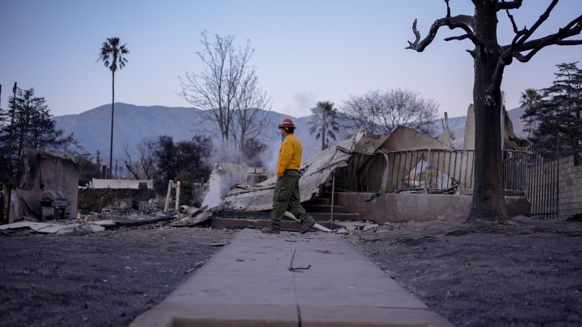 A firefighter examines a destroyed home during the aftermath of the Eaton Fire in Altadena, California, US, on Saturday, Jan. 11, 2025. Firefighters are making some progress on controlling the deadly blazes that have scorched Los Angeles, as the toll of destruction rises with entire neighborhoods reduced to ash. Photographer: Kyle Grillot/Bloomberg via Getty Images