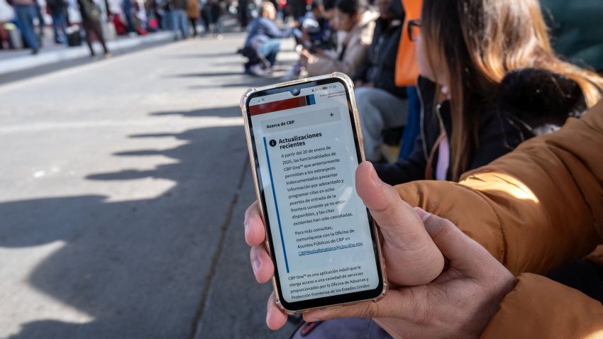 An asylum seeker shows an updated message on the CBP One app mentioning that all appointments have been cancelled as they wait for their CBP One appointment with US Authorities before crossing through El Chaparral port in Tijuana, Baja California state, Mexico, on January 20, 2025.