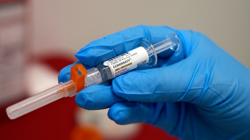 FILE - A pharmacist holds a COVID-19 vaccine at a pharmacy in New York, on Sept. 24, 2024.