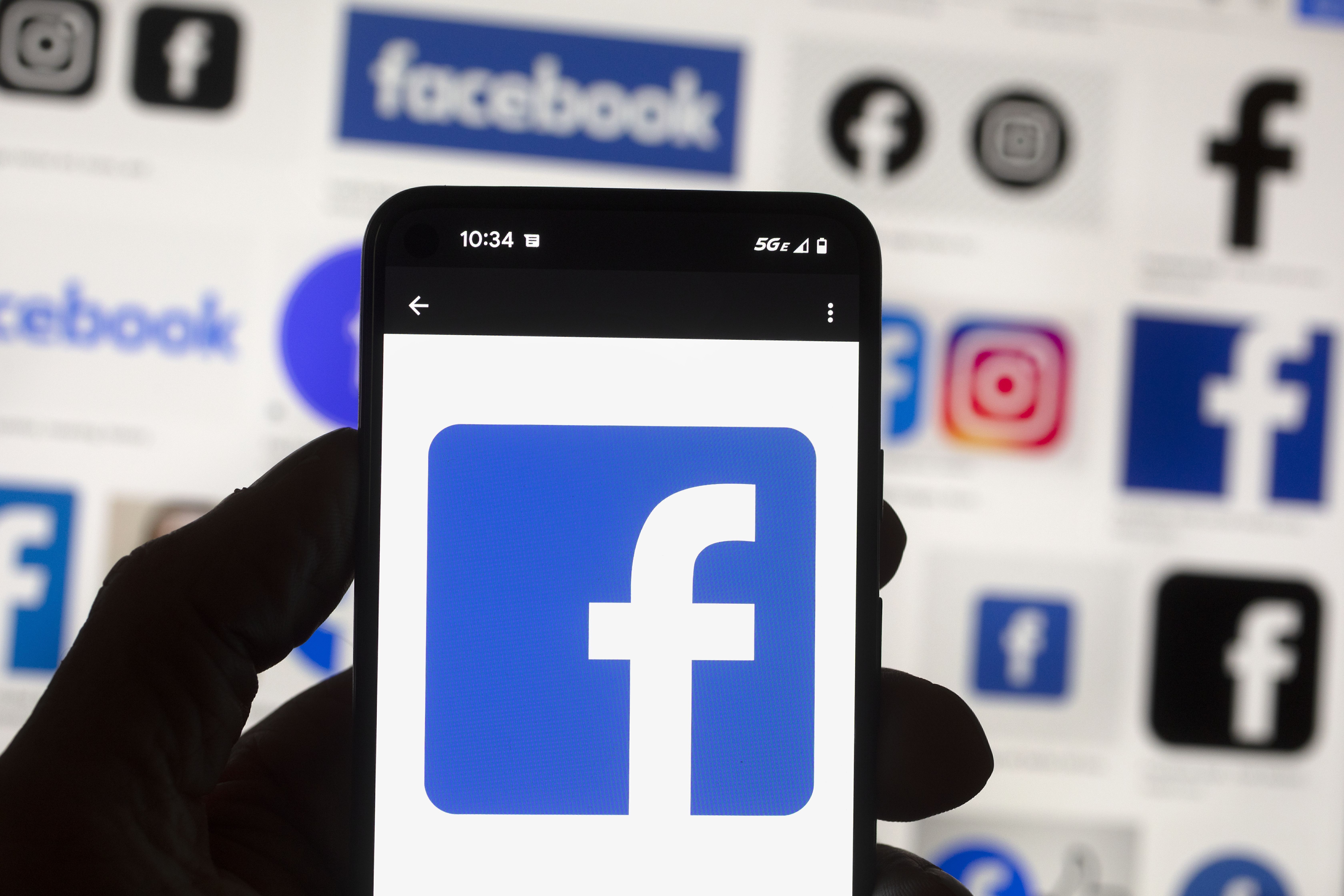 The Facebook logo is seen on a cell phone