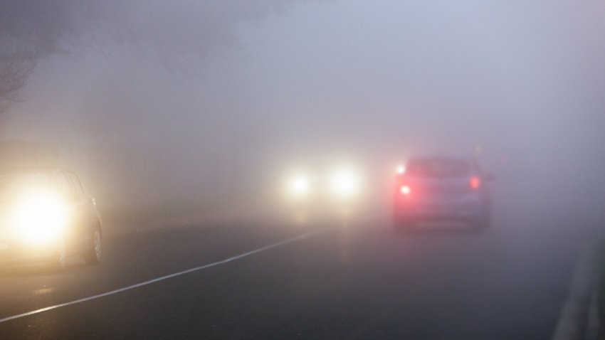 Motor vehicles on a cold, wet morning with headlights on. (Stock photo)