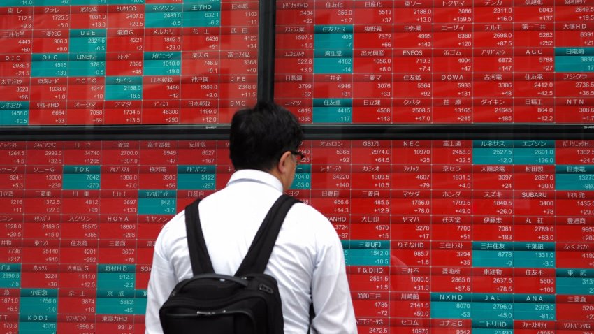 A man looks at an electronic board displaying stock prices of the Nikkei 225 listed on the Tokyo Stock Exchange in Tokyo on April 30, 2024.