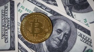 The new Bitcoin token is photographed on U.S. $100 bills.