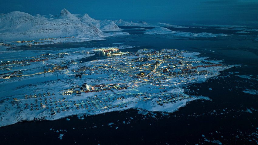 Houses covered by snow are seen on the coast of a sea inlet of Nuuk, Greenland