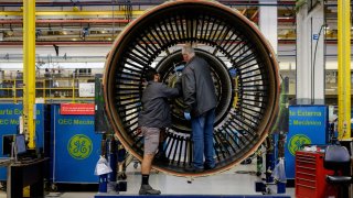 Men work with a jet engine at General Electric (GE) Celma, GE’s aviation engine overhaul facility in Petropolis, Rio de Janeiro, Brazil.