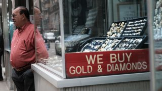 A sign advertises that a store buys gold in Manhattan’s jewelry district in New York City. Gold slipped on Wednesday as the dollar and U.S. Treasury yields advanced after hawkish comments from Federal Reserve officials hinted at continuing aggressive interest rate hikes in the near term.