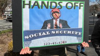 A person holds a sign during a protest against cuts made by U.S. President Donald Trump’s administration to the Social Security Administration, in White Plains, New York, U.S., March 22, 2025.