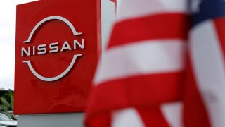 FILE PHOTO: The American flag flutters at a Nissan automobile dealership in Irvine, California, U.S., March 27, 2025.