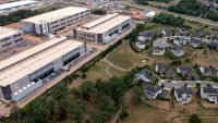 In an aerial view, an Amazon Web Services data center is shown situated near single-family homes on July 17, 2024 in Stone Ridge, Virginia.