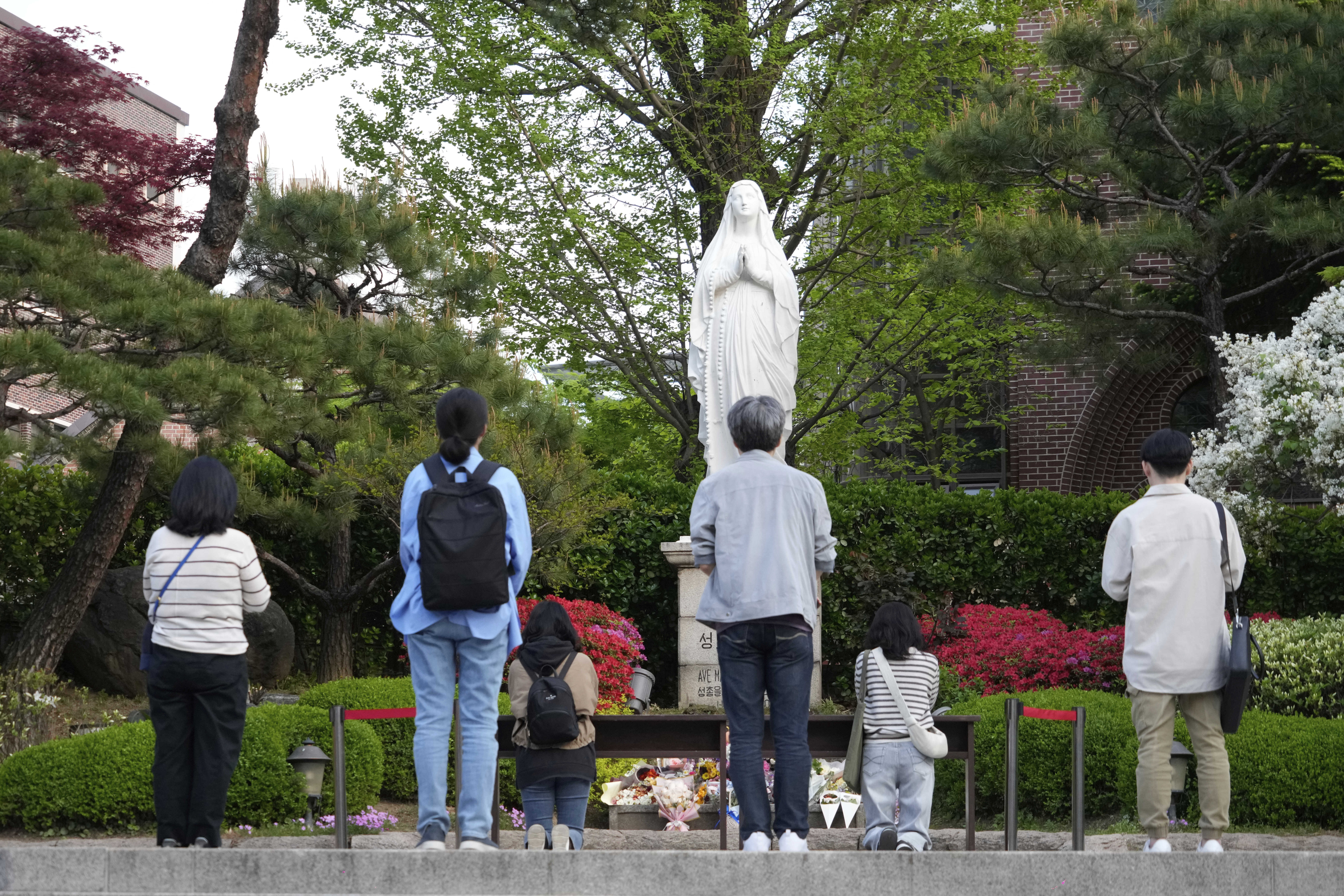 Catholic believers pray after the news of Pope Francis’s death at Myeongdong Cathedral in Seoul, South Korea, Monday, April 21, 2025.