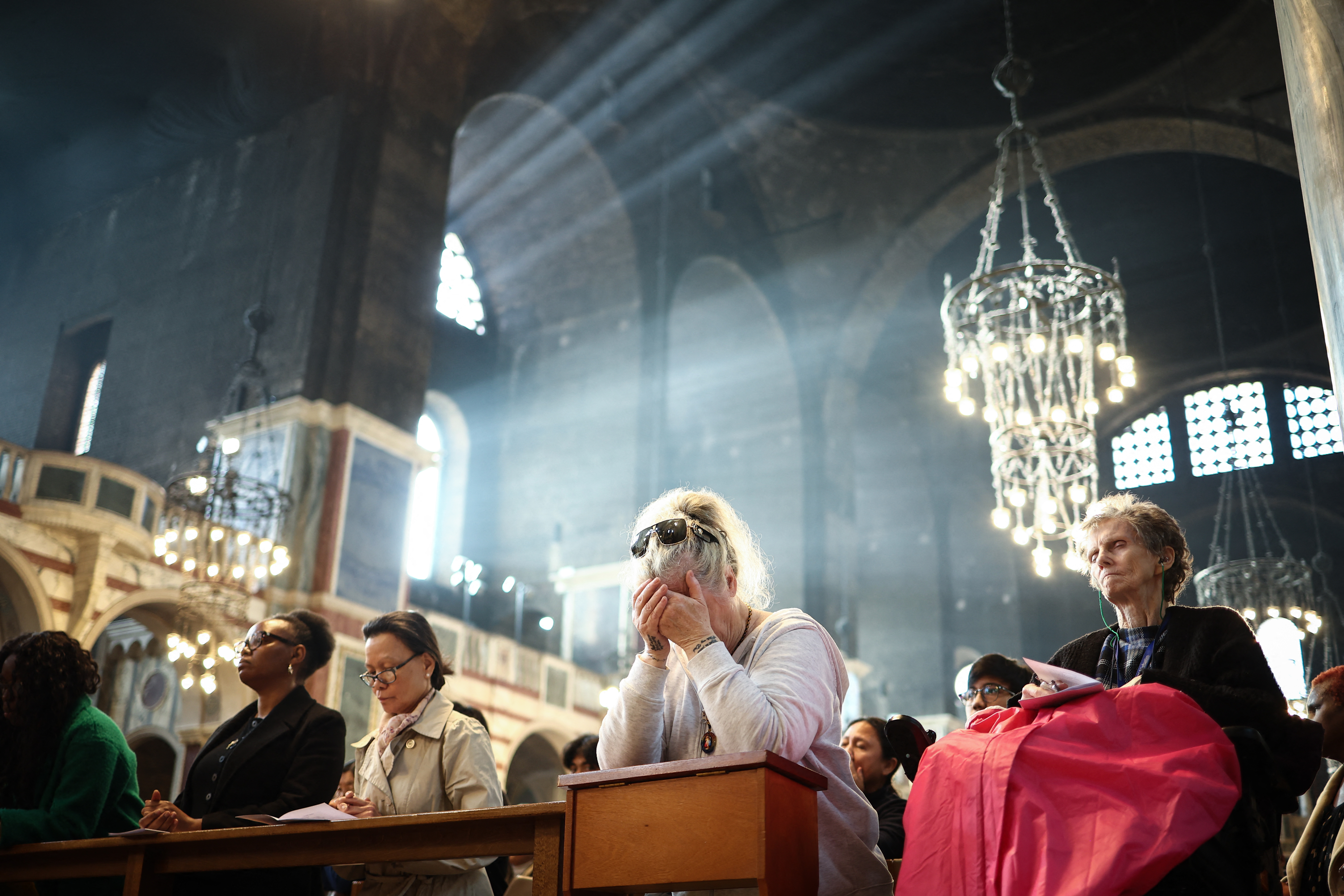 People pray as they attend a solemn requiem at The Metropolitan Cathedral of the Most Precious Blood, informally known as Westminster Cathedral, in central London on April 21, 2025, following the news of the death of Pope Francis.