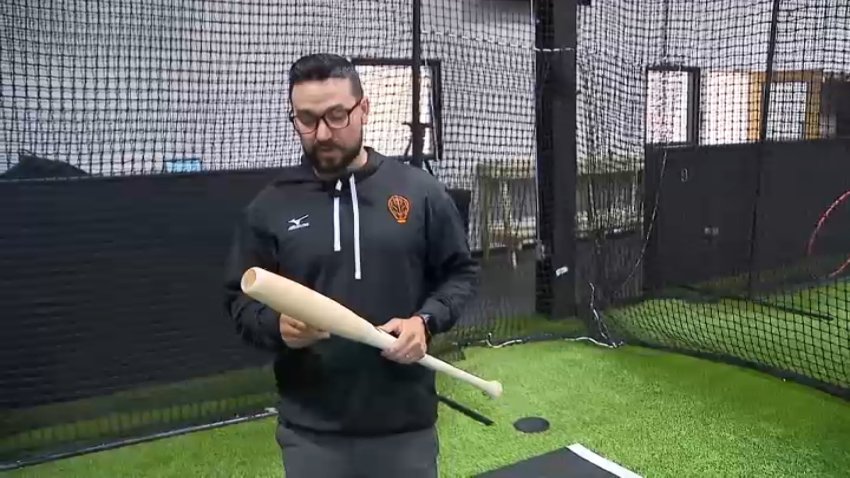 Dan Hennigan, of Brain and Barrel Hitting examines one of Victus Sports' new torpedo bats.