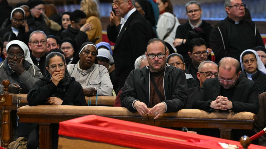 Faithful react next to the coffin as they pay their respects to late Pope Francis inside St Peter’s Basilica in The Vatican, on April 24, 2025. The Vatican said on April 24, 2025, that nearly 50,000 people had so far paid their respects to Pope Francis, whose body is lying in state at St Peter’s Basilica for three days before his funeral. (Photo by Andreas SOLARO / AFP) (Photo by ANDREAS SOLARO/AFP via Getty Images)