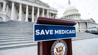 A “Save Medicaid” sign is affixed to the podium for a House Democrats’ press event to oppose the Republicans’ budget, on the House steps of the Capitol, Feb. 25, 2024.