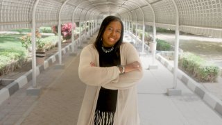Nicole Brewer stands in a covered walkway at the university she teaches at in Nizwa, Oman.