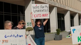Sarah Jo Marcotte, an educator from Vermont, holds a sign that reads “Here for my students!! Cuts Hurt.” outside of the U.S. Department of Education on March 20, 2025 in Washington, DC.