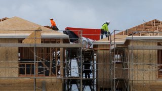 Construction workers use wood and lumber to build residential homes in Irvine, California, U.S., March 28, 2025.