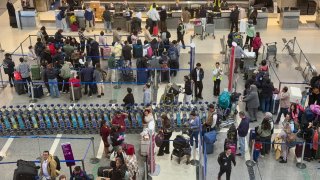 People line up at departures gates in Los Angeles International Airport.