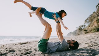 A father and child play on a beach off Tokyo Bay, Japan.