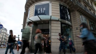 People walk past the entrance of a Gap store in Paris, France, July 1, 2021.